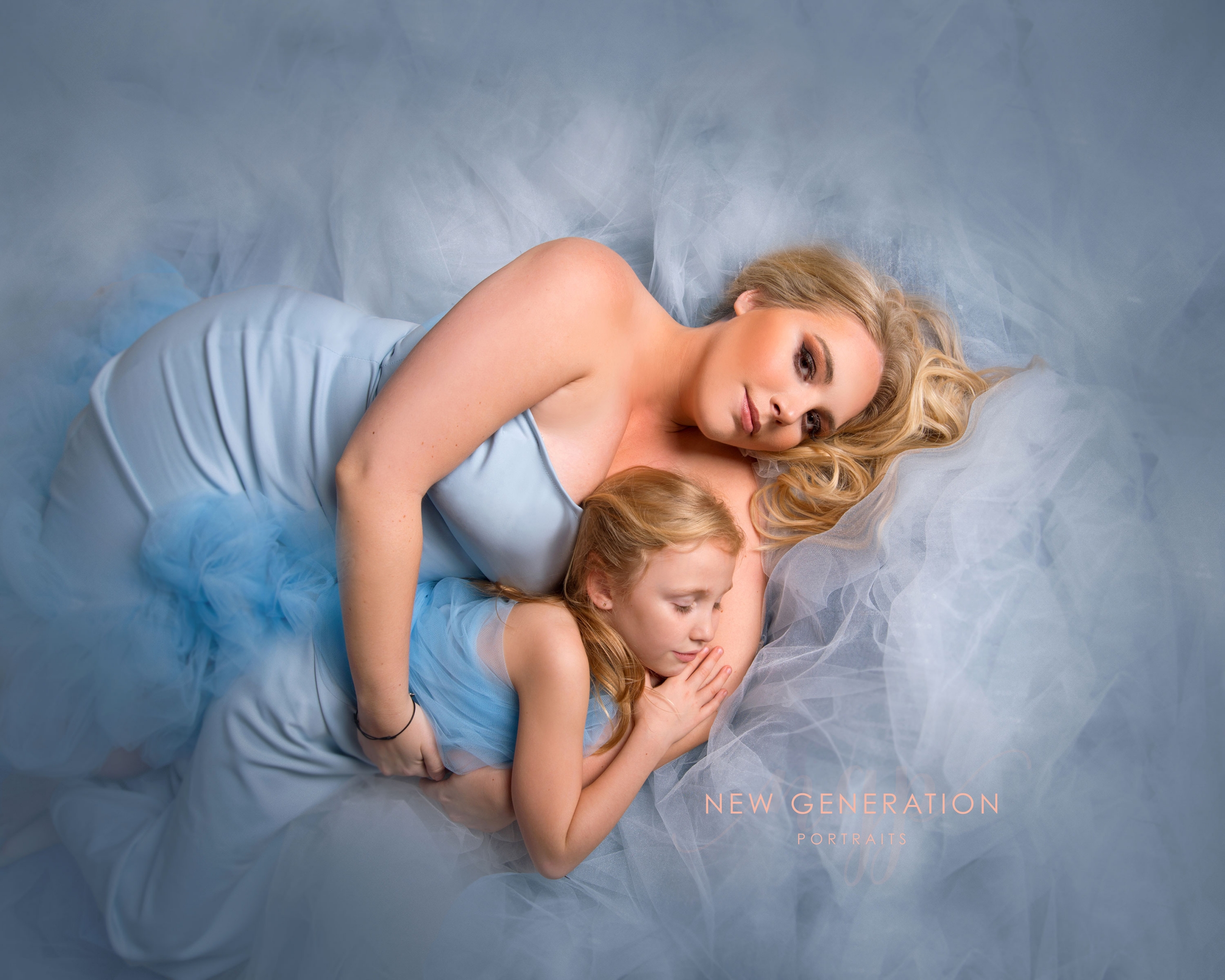Mum and me portrait in matching blue dresses. Safe in mums arms. Captured by New Generation Portraits Ltd