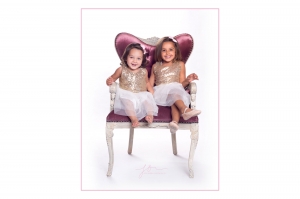 Sisters sitting on the princess chair. Captured by New Generation Portraits.