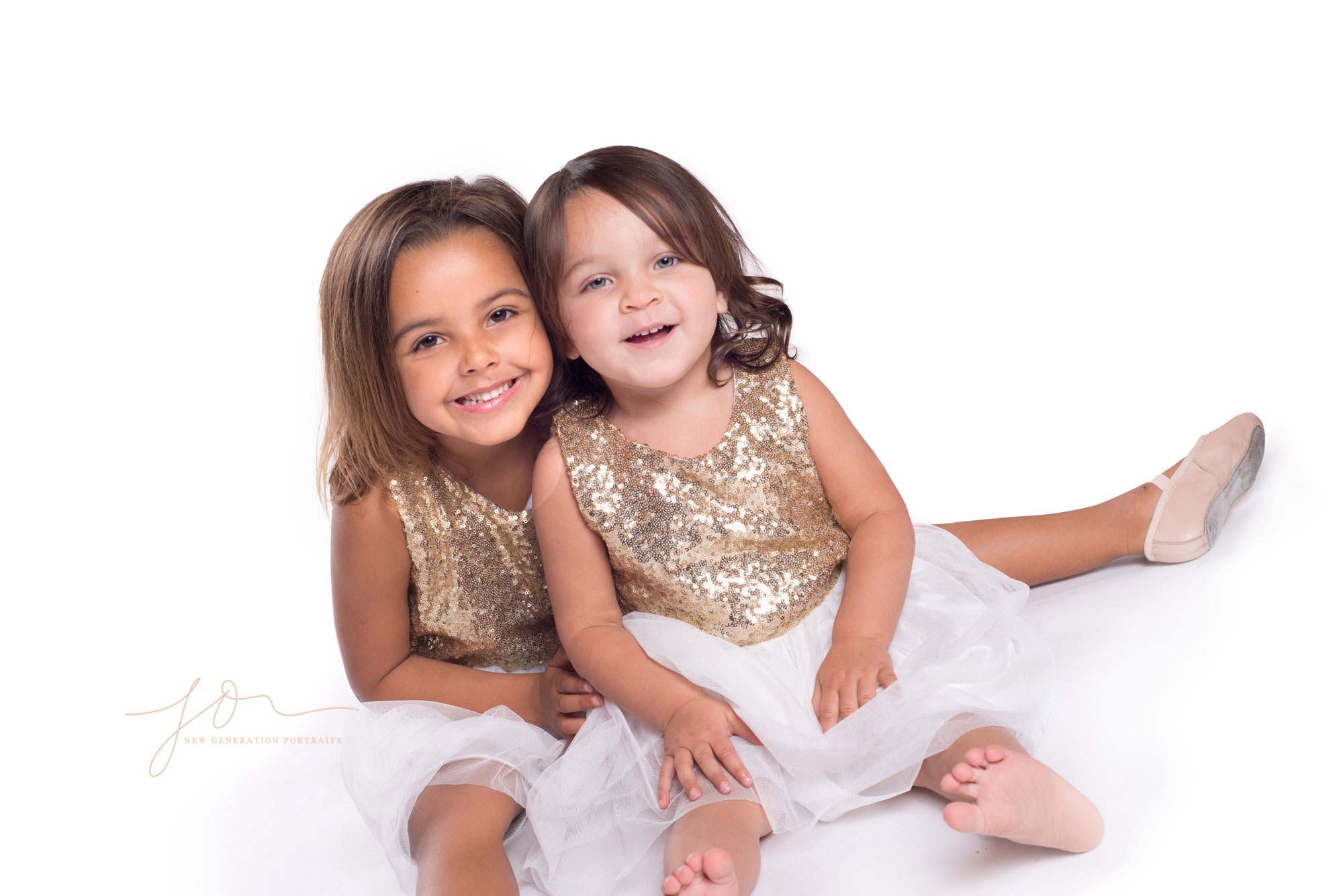 Sisters Laughing at the photographer at their family portrait shoot captured by New Generation Portraits.