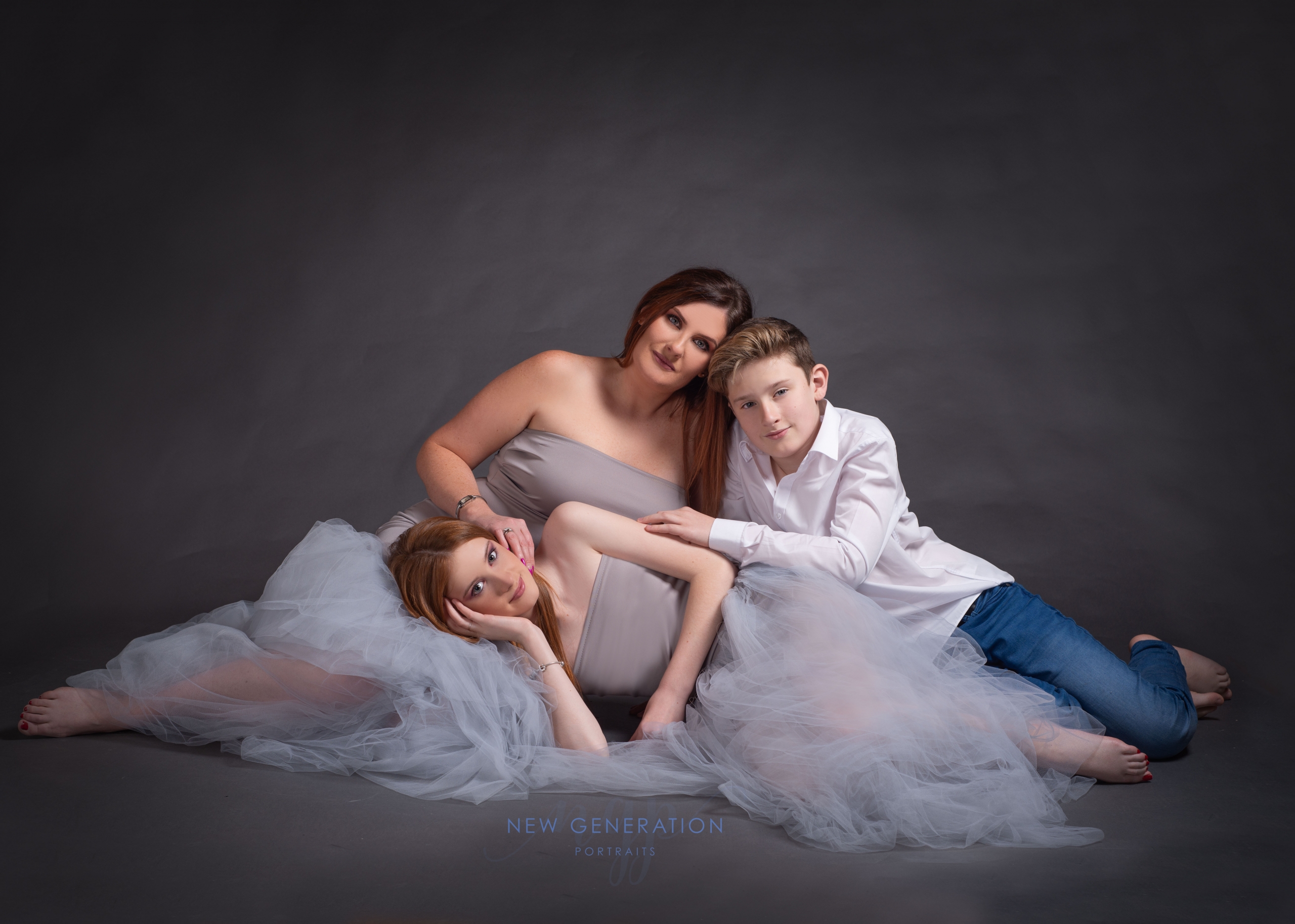 Mum with daughter and son grouped on the floor in drey dress Mum and me. Captured by New Generation Portraits