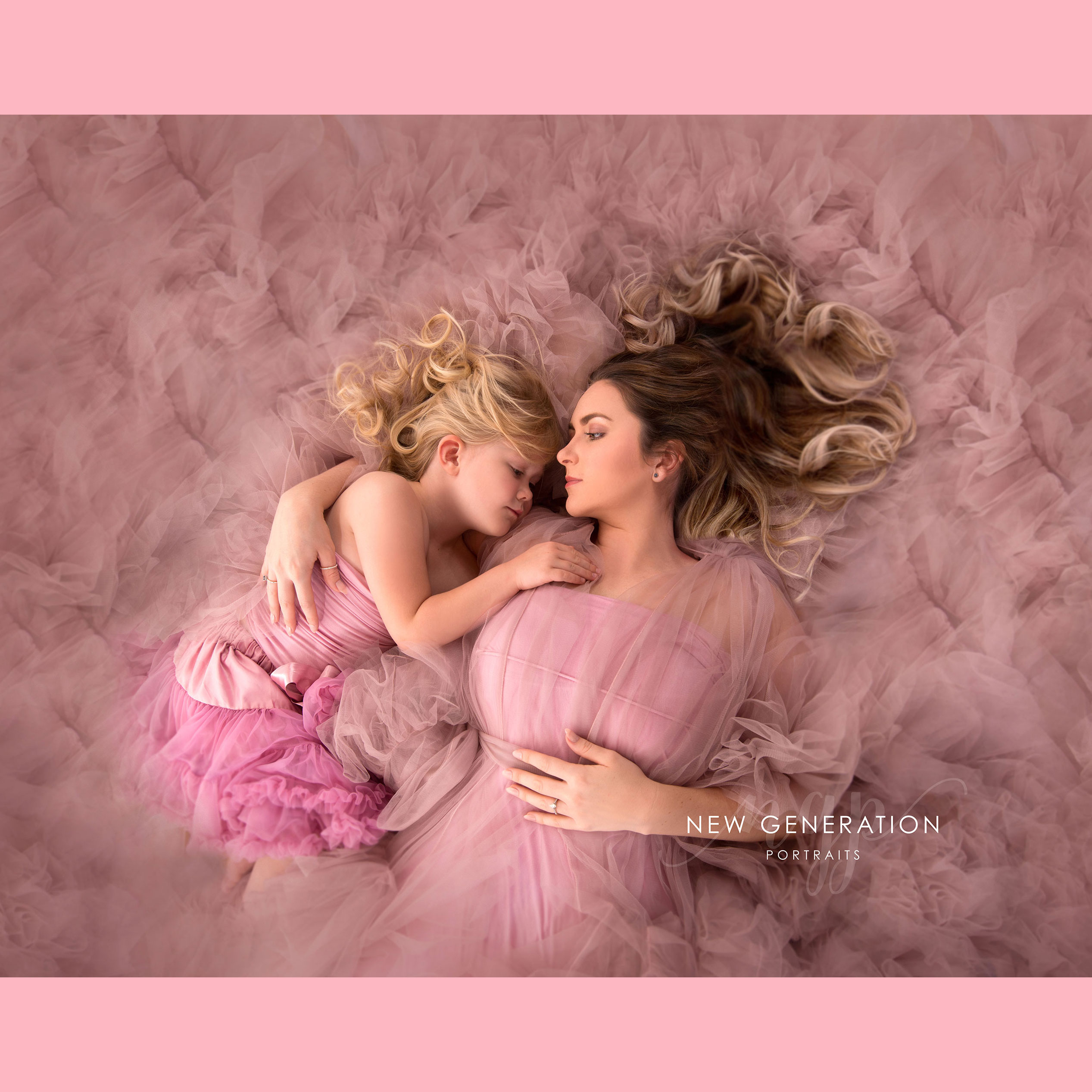 Pink mum and me with flowing hair and pink ruffles. Captured by New Generation Portraits.