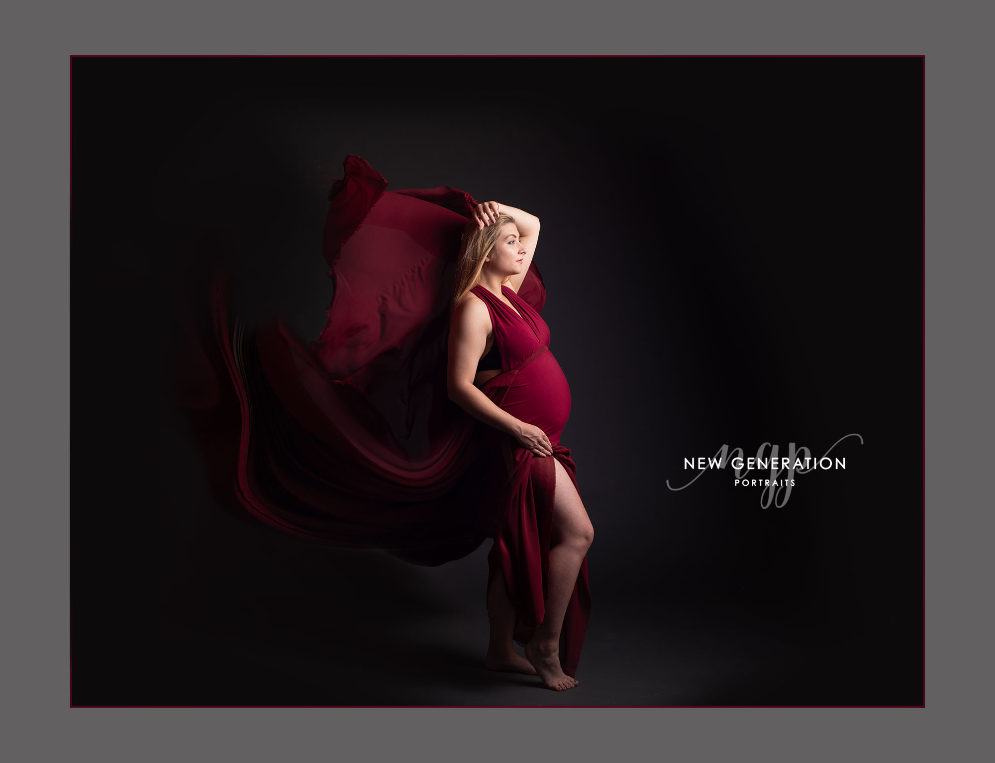 Pregnant lady In red bellowing dress side on showing profile of her bump.Captured by New Generation Portraits.