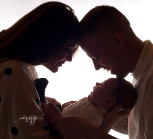 Silhouette of young family with their baby. Captured by New Generation Portraits