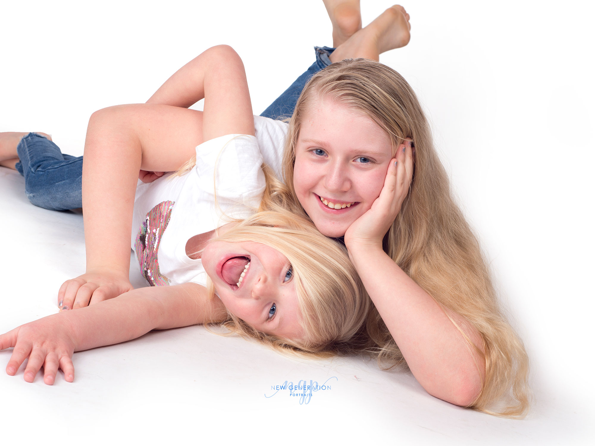 Sisters having fun playing around at their family studio portrait. Captured by New Generation Portraits