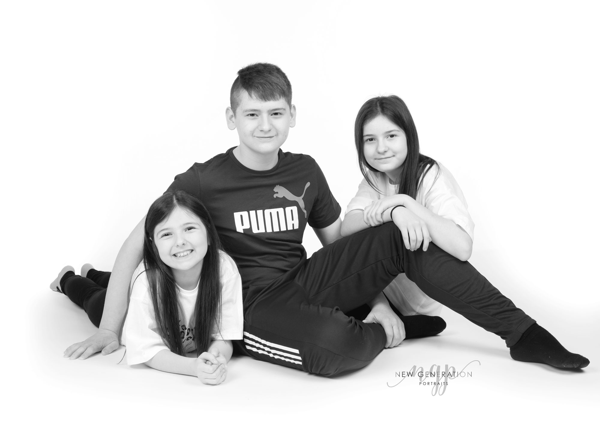 Siblings grouped together for their family portrait in black and white. Captured by New Generation Portraits