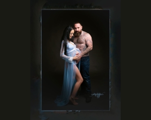 Pregnant lady in blue dress standing with partner.Captured by New Generation Portraits